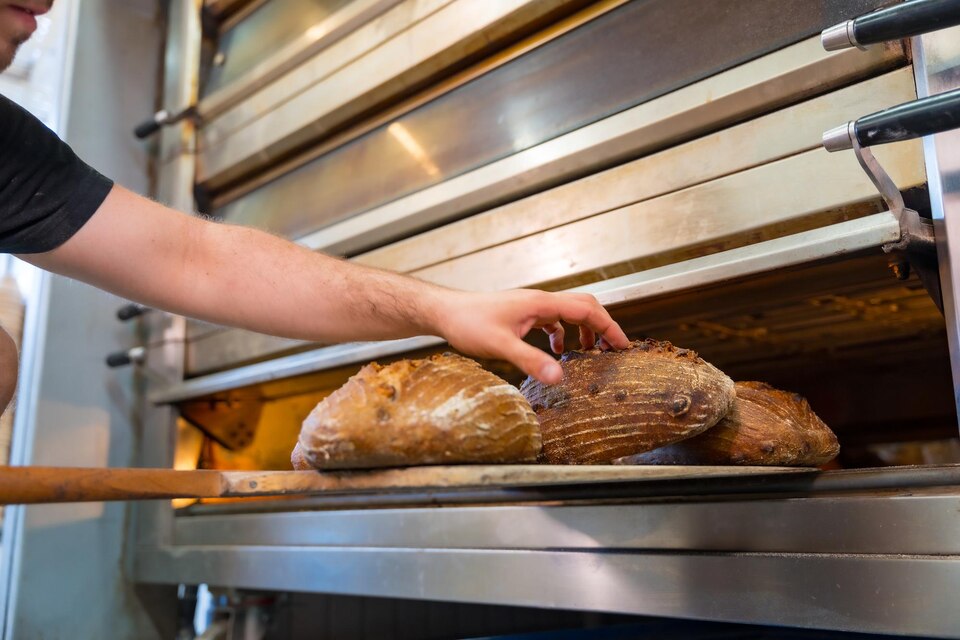 [freepicdownloader.com]-lavoratore-maschio-panettiere-di-panetteria-in-officina-officina-di-panettieria-artigianale-panettiere-in-forno-large